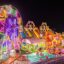 1024px-Illuminated_Ferris_wheel,_bouncing_castle_and_carousel_at_night_in_a_funfair_in_Vientiane,_Laos