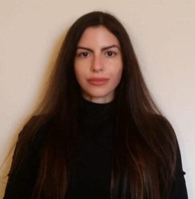 Latina woman with long brown hair, dark eyes, and black long-sleeve shirt