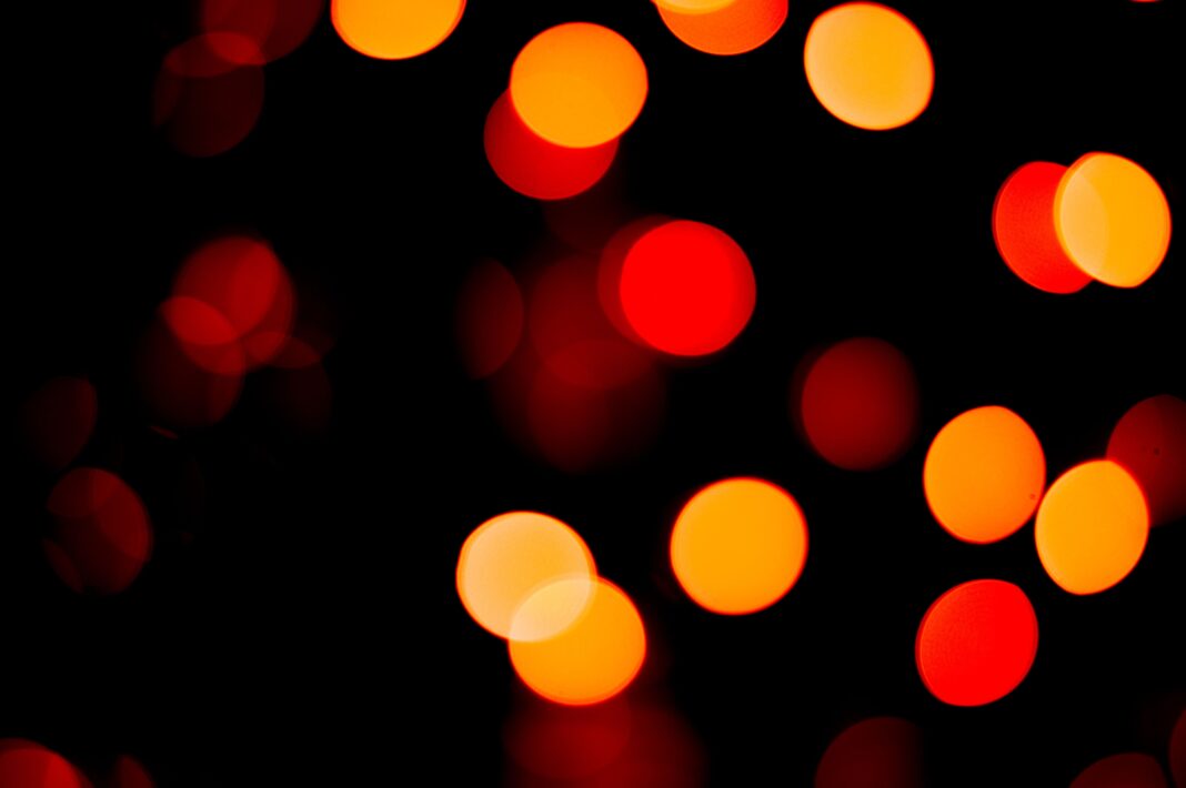 Vivid bokeh lights in red and orange create a captivating abstract background.